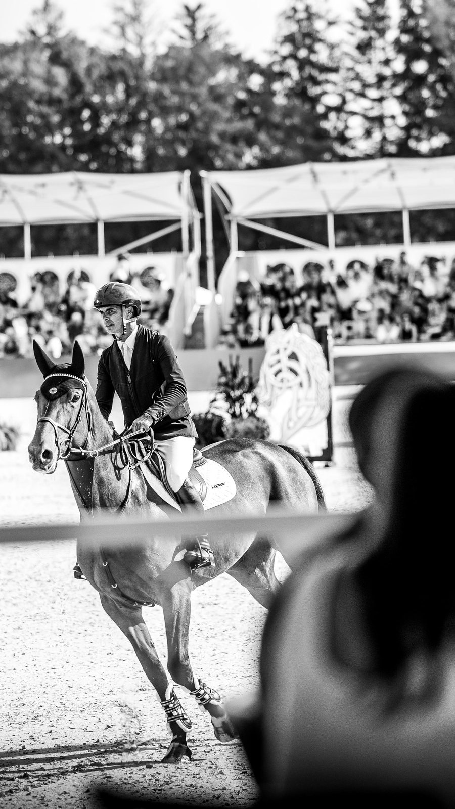 A rider passes guests watching from the ringside tables